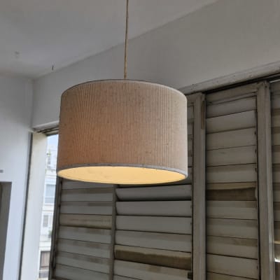 מנורה תלויה מהתקרה בחדר עם תריסים