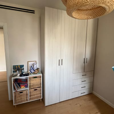 ארון בגדים לבן עם ידיות מתכת בחדר שינה