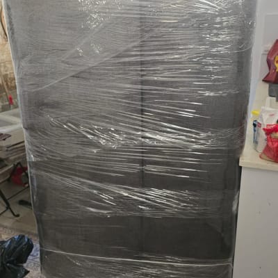 ספה אפורה עטופה בניילון נצמד להגנה לפני הובלה