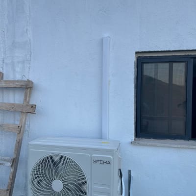 יחידת מזגן חיצונית מותקנת על קיר לבן