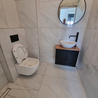 שירותים עם כיור עגול, אריחים חדשים ומאוורר קיר