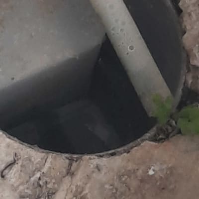 צינור פלסטיק בתוך פתח ביוב על רצפה