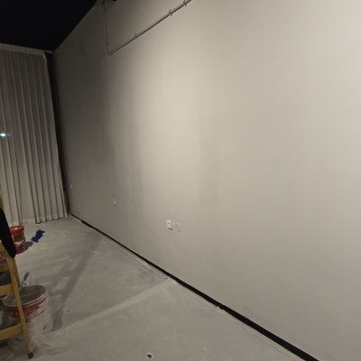 קיר צבוע בלבן עם דלי צבע ומברשת