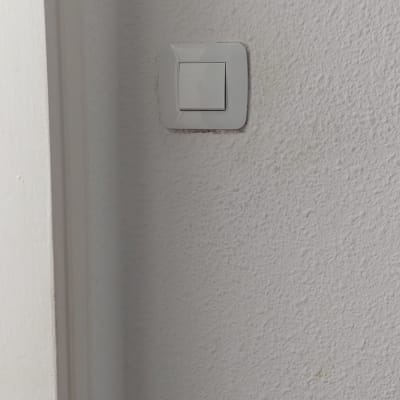 מתג חשמל לבן על קיר לבן