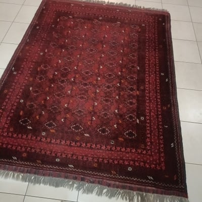 שטיח אדום על רצפת אריחים עם כלי ניקוי בפינה