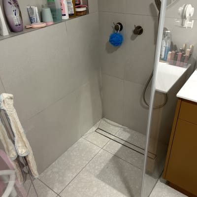 מקלחת עם מדף מוצרי טיפוח ומגבת תלויה