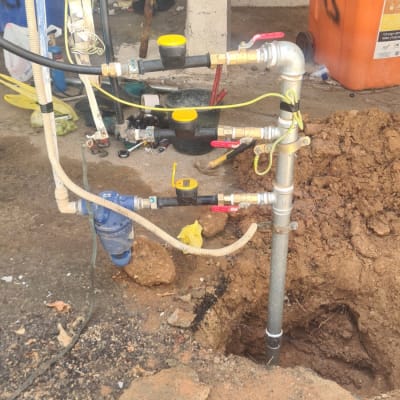 צינורות מים עם ברזים וכלי עבודה באתר חפירה