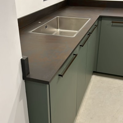 מטבח עם משטח עבודה כהה וכיור נירוסטה