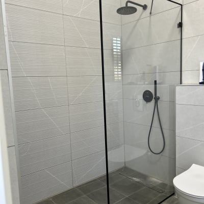 מקלחת עם דלת זכוכית וברז שחור