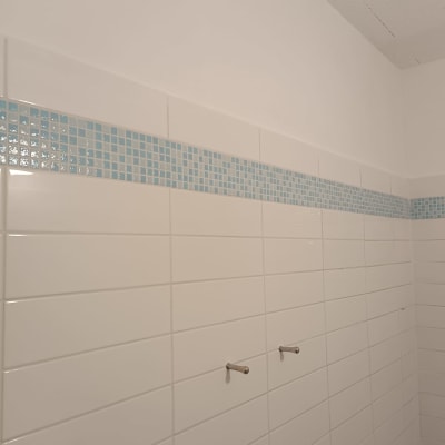 קיר עם אריחים לבנים ופס אריחים כחולים