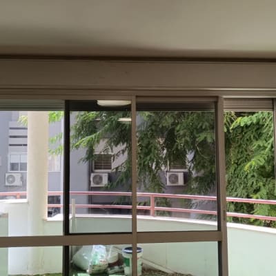 תריסים זכוכית במרפסת עם נוף לעצים