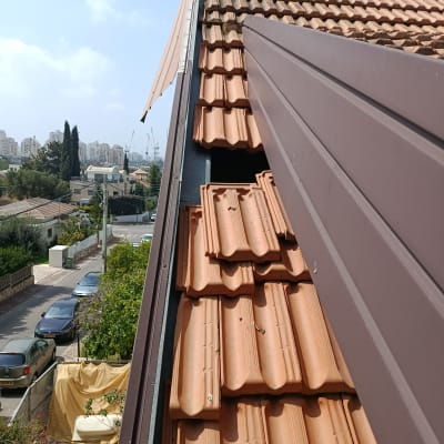 גג רעפים עם נוף עירוני ברקע