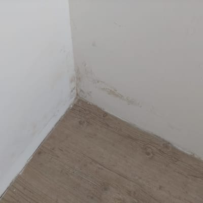 פינת קיר עם סימני רטיבות ותיקונים