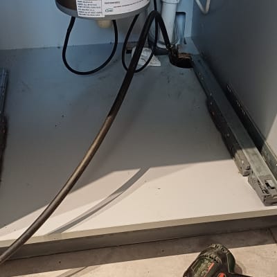 כלי עבודה וצנרת מתחת לכיור במטבח