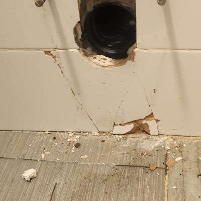 צינור מים חשוף עם מפתח ברגים על הרצפה