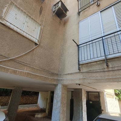 מזגנים מותקנים על קיר בניין עם רשתות הגנה