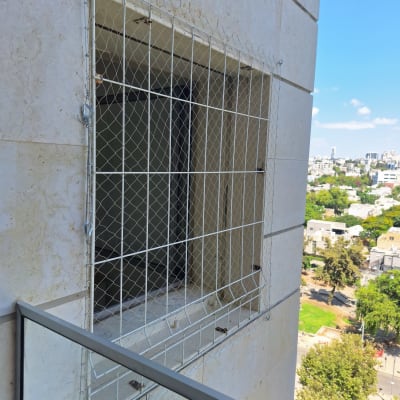 רשת על חלון למניעת כניסת יונים בבניין גבוה