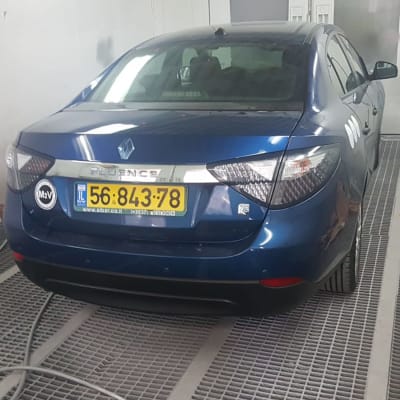 מכונית כחולה בחדר צבע עם ניירות על הרצפה