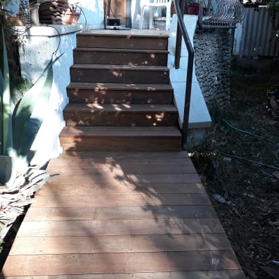 מדרגות עץ עם מעקה מתכת בגינה