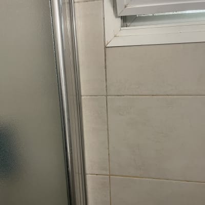 דלת מקלחת מזכוכית עם מסגרת מתכת