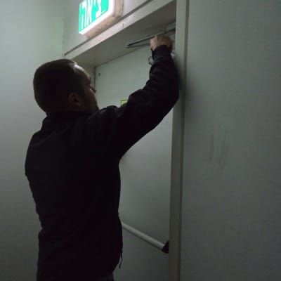 אדם מתקין מנעול על דלת יציאה