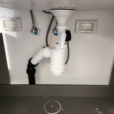 צנרת מתחת לכיור עם חיבורים ואביזרים