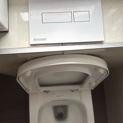 אסלה עם לחצן הדחה כפול על הקיר