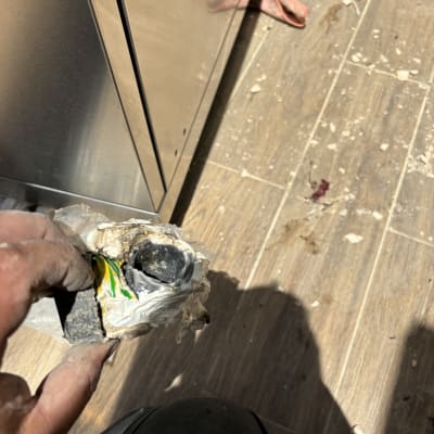 יד מחזיקה צינור עם חוטים חשמליים חשופים