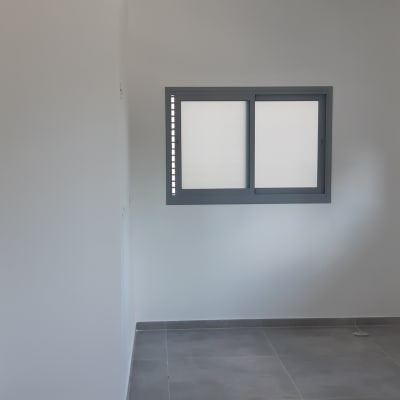 חדר עם רצפת אריחים אפורה וחלון חדש