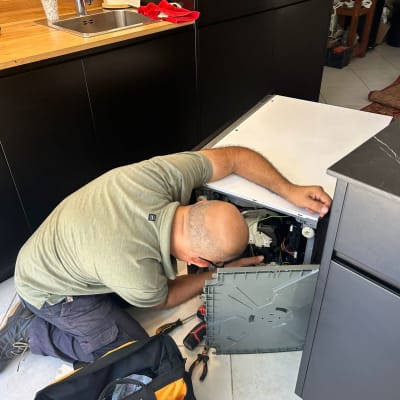 טכנאי מתקן מכשיר חשמלי עם כלים ותיק עבודה