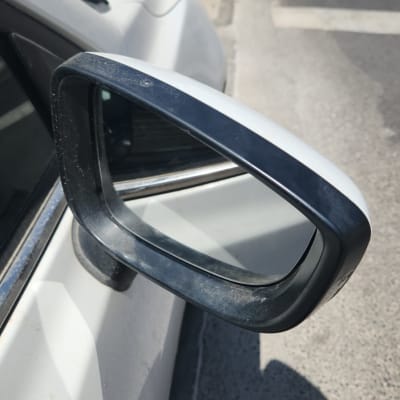 מראת צד של רכב לבן עם לכלוך קל