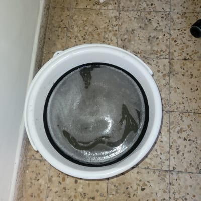 דלי מים על רצפה עם אריחים