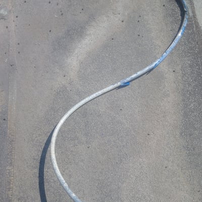 צינור מתכת מעוקל על רצפה עם מגף חום