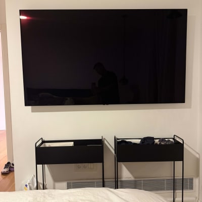 טלוויזיה מותקנת על קיר עם מדפים מתחת