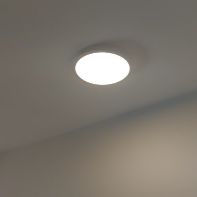 מנורת תקרה עגולה דולקת על תקרה לבנה