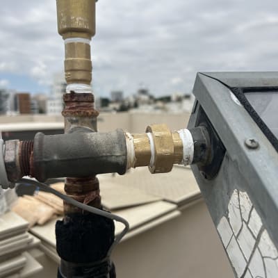 חיבורי צנרת ומחברים על גג עם רקע עירוני