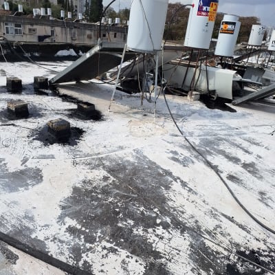 גג עם דודי שמש ואיטום ביטומני שחור ולבן