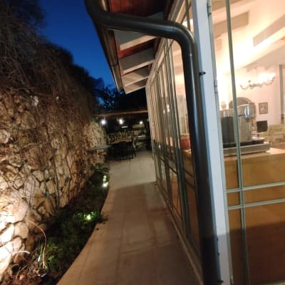 מרזב מחובר לגג מבנה זכוכית בלילה