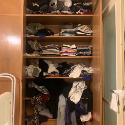 ארון בגדים מבולגן עם בגדים מקופלים ומפוזרים