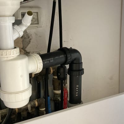 צינורות פלסטיק לבנים ושחורים מתחת לכיור