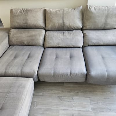 ספה אפורה עם כריות על רצפת עץ