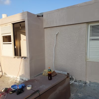 חומרי איטום וכלים על גג ליד חלון