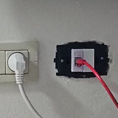 שקע רשת עם כבל אדום מחובר לקיר