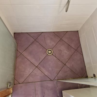 רצפת מקלחת עם אריחים סגולים וניקוז