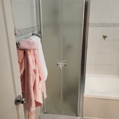 דלת מקלחון עם מגבות ורודות על הקיר