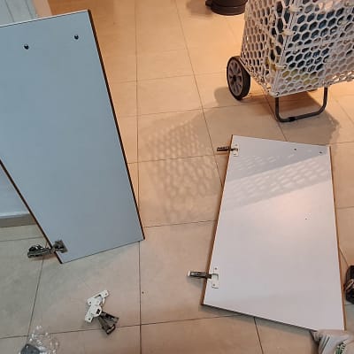 דלתות ארון מפורקות עם מקדחה על הרצפה