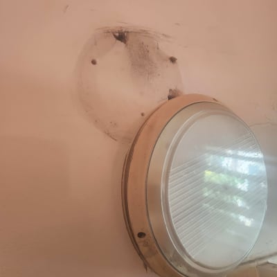 מנורה מותקנת על קיר עם סימני תיקון