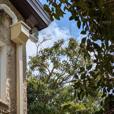 גג עם מרזב לבן וצינור ניקוז