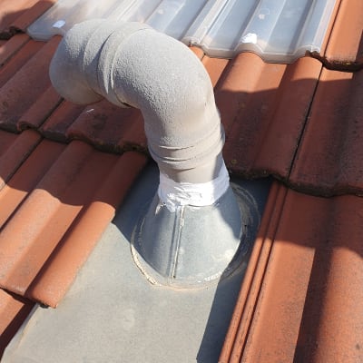 צינור מתכת על גג רעפים אדום