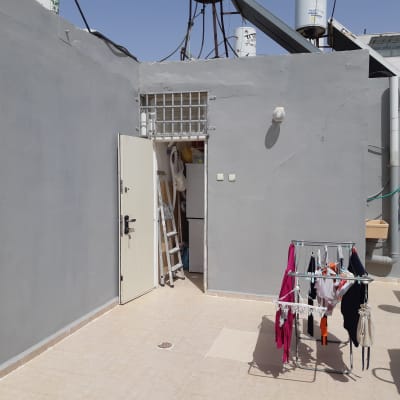 חצר עם דלת פתוחה, סולם וחפצים שונים